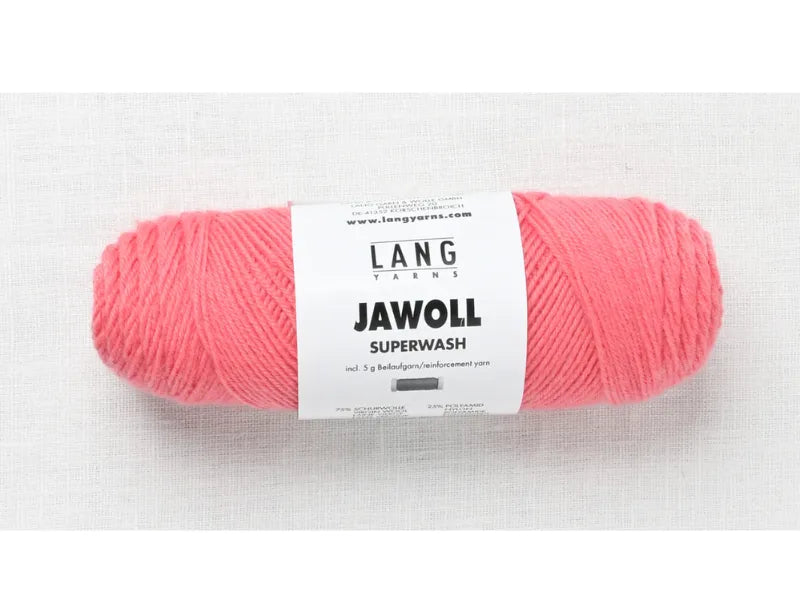 A skein of Timo sukka ohje fingerin ja Lang jawoll pink fingering yarn with a white label, displayed on a light textured surface.