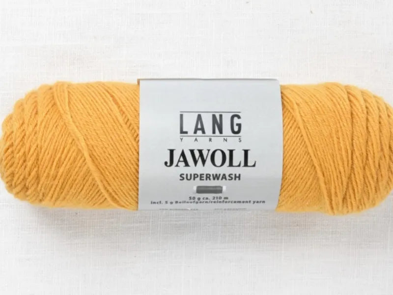 A skein of Timo sukka ohje fingerin ja Lang jawoll in mustard yellow sits on a white textured surface, ideal for your next neulontaohje or sock project.