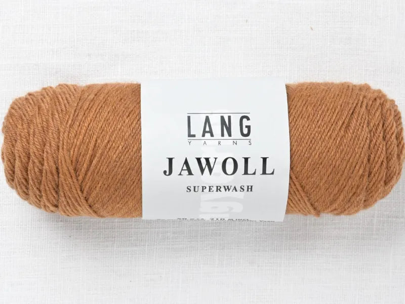 A skein of light brown Timo sukka ohje fingerin ja Lang jawoll yarn with a white label sits on a textured white background—ideal for your next neulontaohje or Timo sukka sock project.