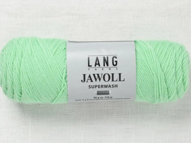 A skein of mint green Lang jawoll yarn rests on a light background. Timo sukka ohje fingerin ja Lang jawoll is perfect for following your favorite neulontaohje or the classic Timo sukka pattern.