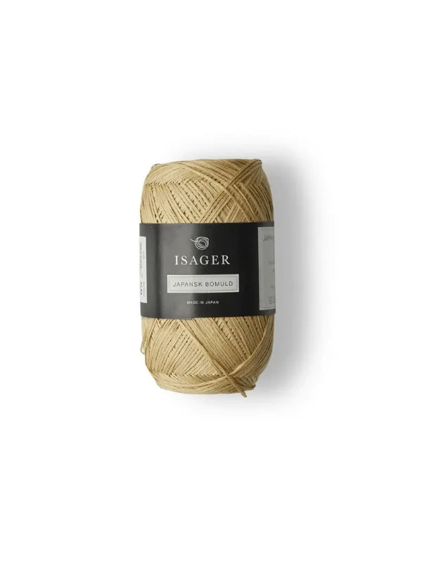 A spool of light tan Isager Japansk Bomuld cotton yarn with a black and white center band, ideal for summer knits, displayed on a plain white background.