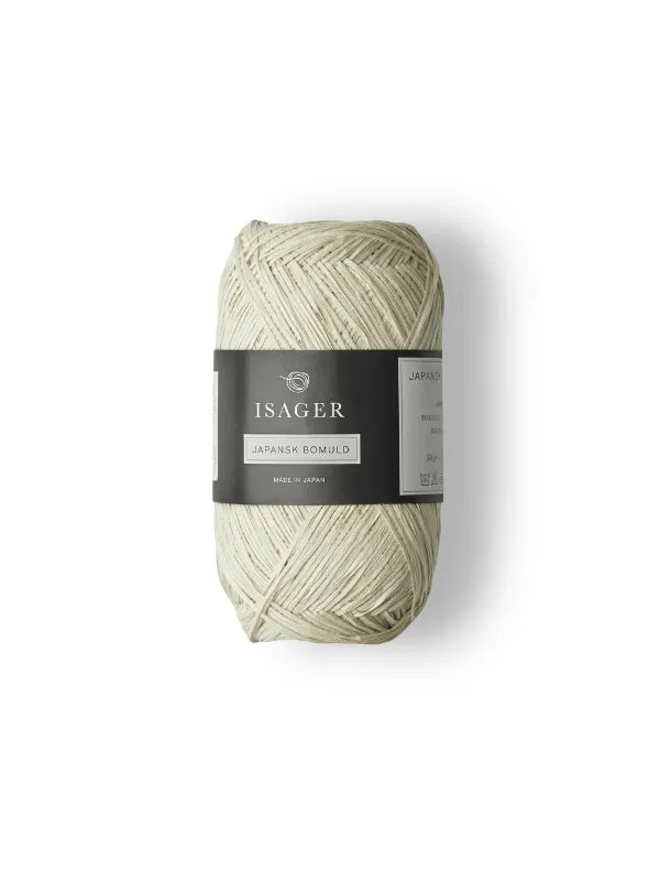 A skein of pale, off-white Isager Japansk Bomuld puuvillalanka with a black and white label, set against a plain white background—ideal for airy summer knits.