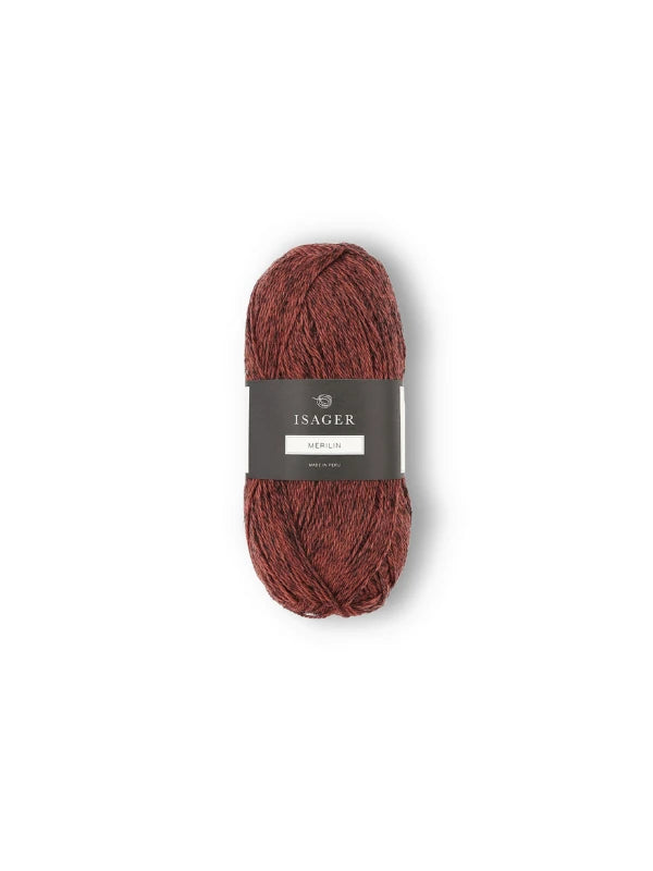 A skein of reddish-brown Isager Merlin yarn with a black label is centered on a white background.