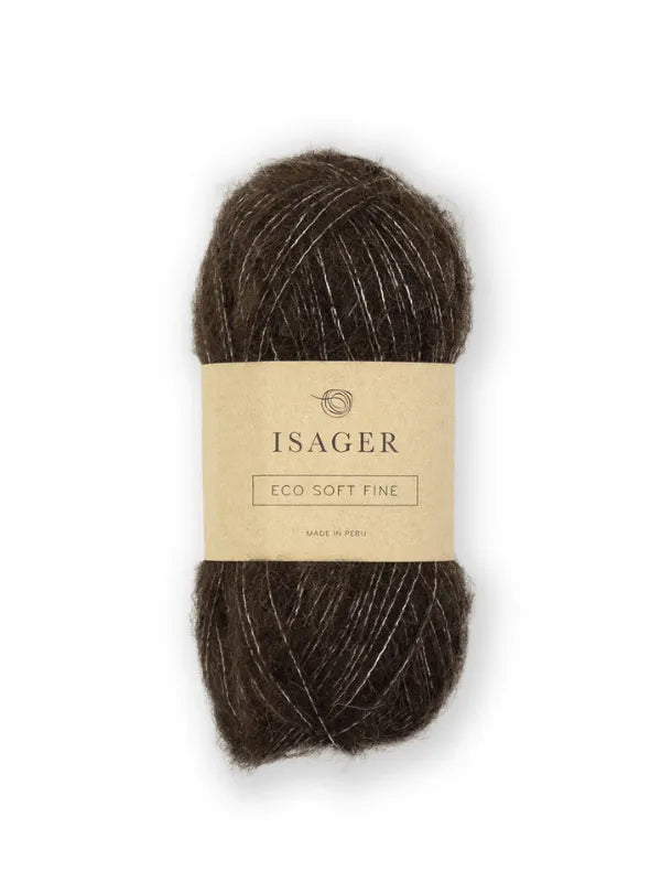 A skein of dark brown Isager Soft Fine yarn with a beige paper label featuring the brand name and product details printed in black.