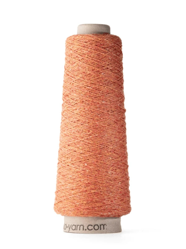 A tall cone of Ito Kinu orange silk yarn with a subtle texture, neatly wound on a spool labeled o-yarn.com, stands upright on a white background—ideal for kesäneuleisiin.
