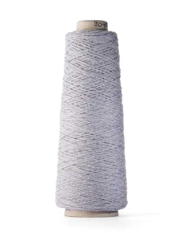A large cone of Ito Yarn Shimo in a light gray color, tightly wound around a cardboard spool, stands upright against a white background.