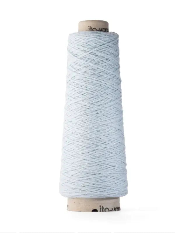 A tall cone of Ito Yarn Shimo in light blue is neatly wound around a cardboard spool and stands upright against a white background.