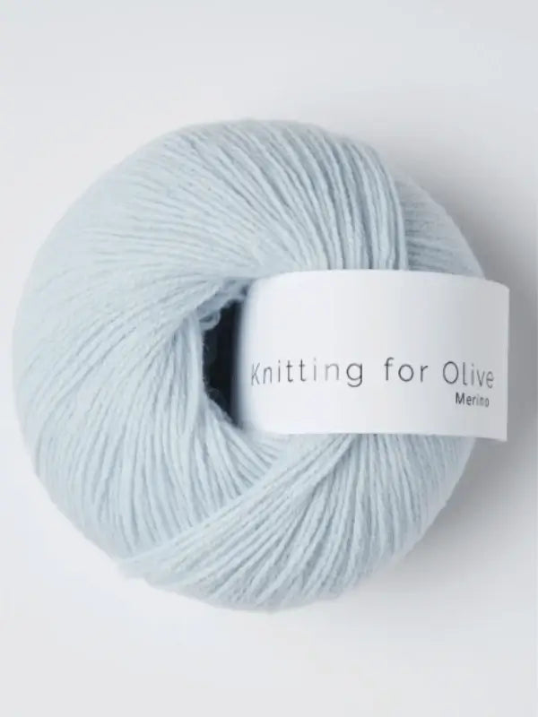 A soft, pale blue ball of Knitting for Olive Merino yarn with a white label is neatly wound, Öko-Tex certified, and set against a plain background.