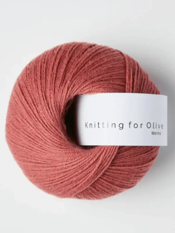 A dusty rose ball of Knitting for Olive Merino yarn with a white label and Öko-Tex certification, displayed against a plain white background.