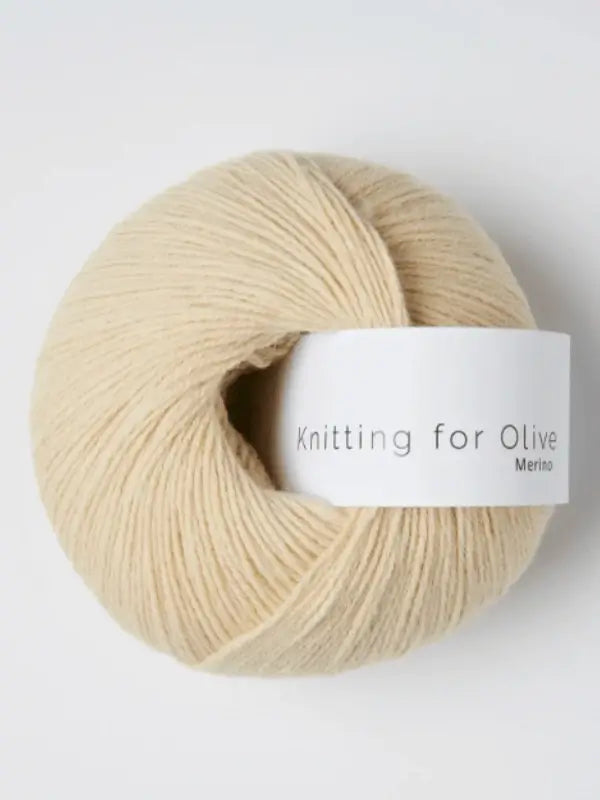 A ball of light beige Knitting for Olive Merino yarn with a white label, made from soft merino wool and certified Öko-Tex for safe, high-quality knitting.