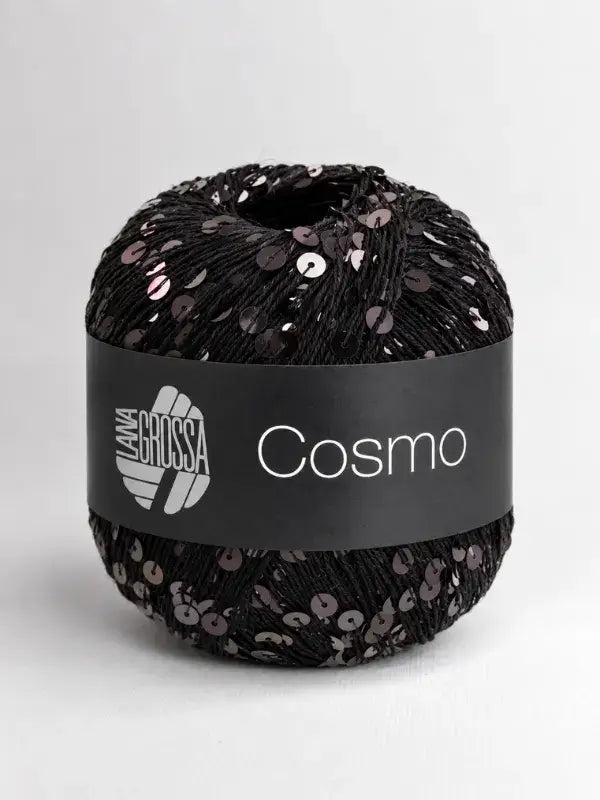 A ball of Lana Grossa Cosmo black yarn embellished with dark, reflective sequins and wrapped in a black product band.