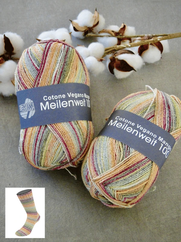 Two skeins of Lana Grossa Meilenweit 100 Cotone Vegano Mango multicolored yarn rest on a gray surface with cotton sprigs behind them. An inset displays a sock knitted from this vegan cotton sock yarn.