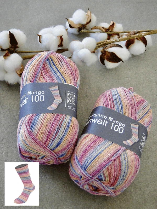 Two skeins of Lana Grossa Meilenweit 100 Cotone Vegano Mango yarn with sock labels lie on a gray surface beside a cotton branch, highlighting this vegan puuvillasukkalanka—an ideal villaton sukkalanka alternative.