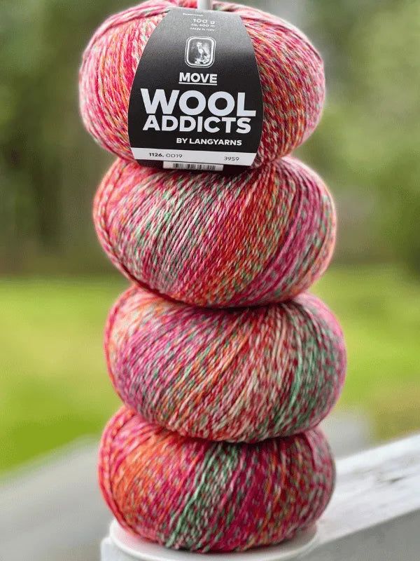 Three balls of Lang Yarns Wool Addicts Move 4 sukkalanka yarn in red, pink, green, and white are stacked vertically outdoors. The top ball features a black label with the product name.