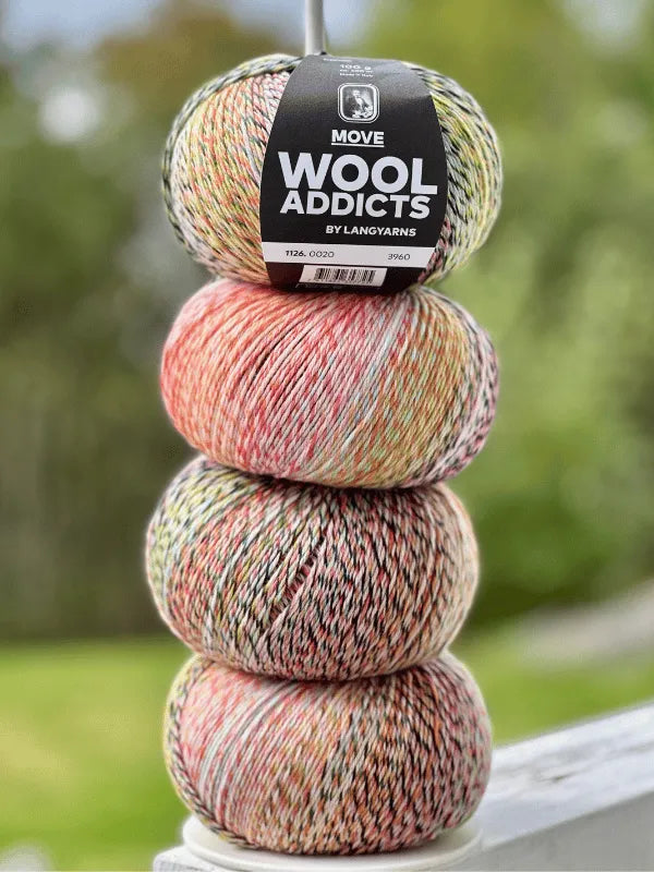 Three multicolored balls of Lang Yarns Wool Addicts Move 4 yarn are stacked vertically outdoors, with a blurred green background.