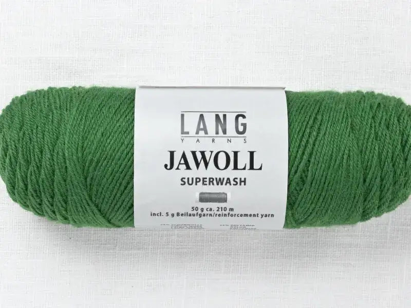 A skein of green Lang Yarns Jawoll with a white label, including 5 grams of reinforcement yarn.