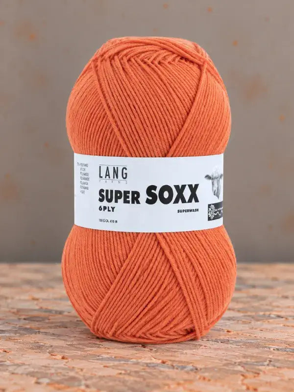 A ball of bright orange Lang Yarns Super Soxx 6 ply – kestävä sukkalanka villasta yarn wrapped in a branded label.