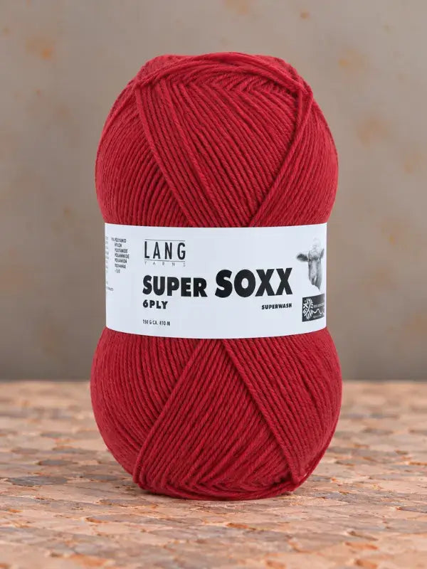 A ball of red Lang Yarns Super Soxx 6 ply – kestävä sukkalanka villasta yarn with a white label.