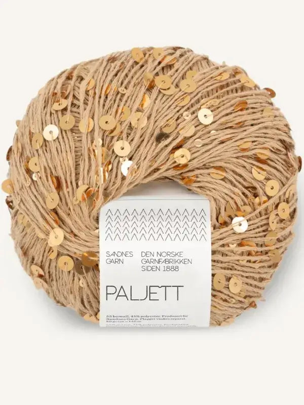 A ball of tan Sandnes Garn Paljett yarn adorned with gold sequins, featuring a product label with geometric patterns and text.