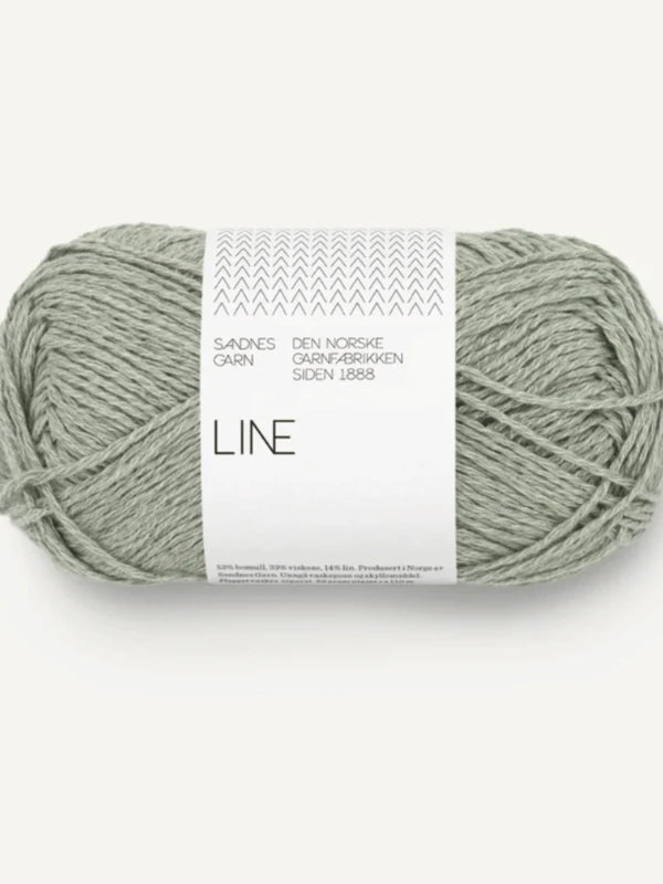 A skein of Sandnes Garn Line yarn for PetiteKnit Anker's Summer Shirt in light gray-green, with product details on a white paper band wrapped around the yarn.