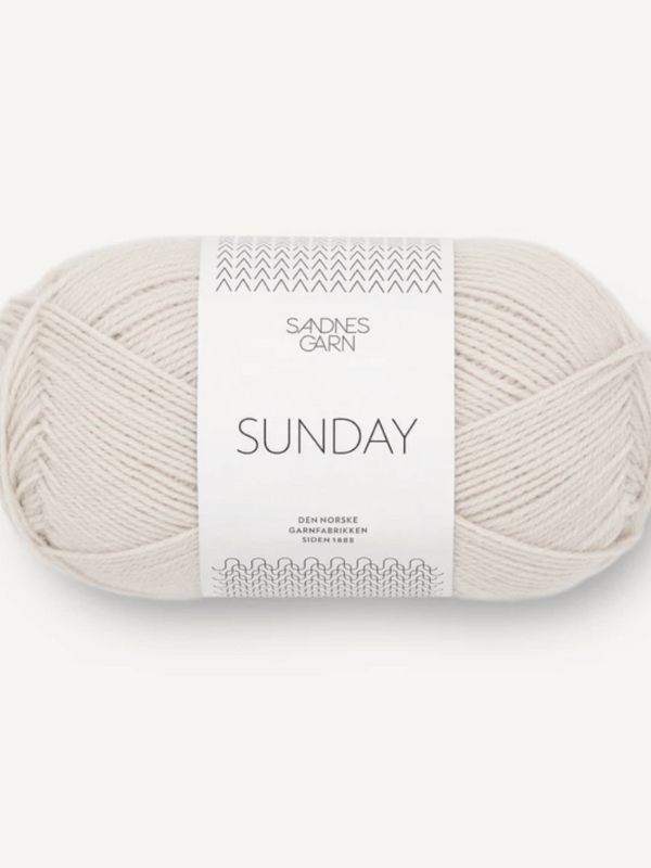A skein of Sandnes Garn Sunday in light beige, a fingering-weight yarn made from mulesing-free merino wool, with a white label featuring black text and simple designs.
