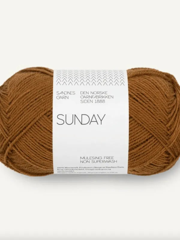 A skein of brown Sandnes Garn Sunday merinovillalanka, mulesing-free, with a white label showing the brand name and care info, set against a plain light background.