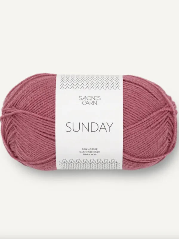 A skein of dusty pink Sandnes Garn Sunday fingering-weight yarn made from mulesing-free merino wool, neatly wound with a white label featuring gray text, displayed on a plain, light background.