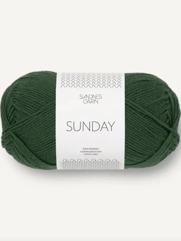 A skein of Sandnes Garn Sunday yarn in dark green, wrapped with a white band that displays minimalist patterns and text.