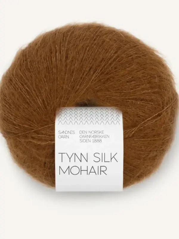 A ball of brown Sandnes Garn Tynn Silk Mohair yarn, with the label wrapped around the center of the skein.