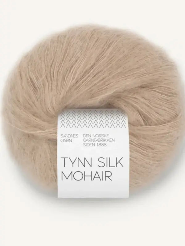 A ball of Sandnes Garn Tynn Silk Mohair in beige, wrapped with a white paper label featuring both Norwegian and English text, from the esteemed Sandnes Garn collection. This luxurious silk mohair yarn is ideal for creating delicate, airy projects.