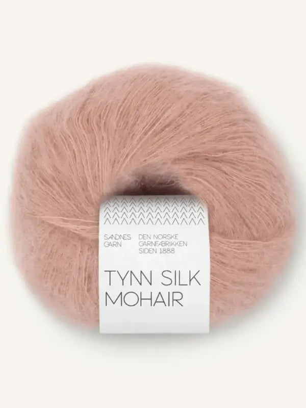A ball of soft, pink-brown mohair yarn labeled Sandnes Garn Tynn Silk Mohair features a white tag with Norwegian text wrapped around the skein; this premium yarn combines delicate silk and mohair fibers for luxurious, lightweight projects.