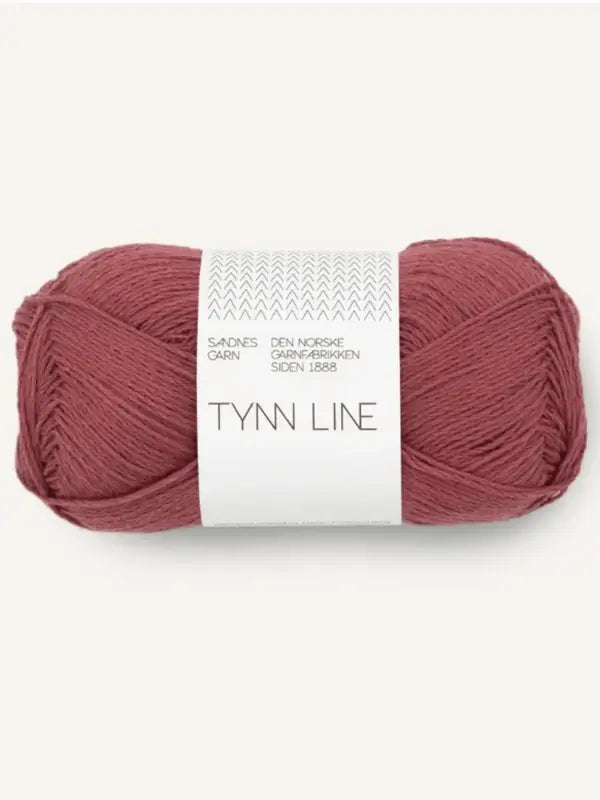 A skein of Sandnes Garn Tynn Line, a fingering-weight yarn in dusty rose, features a white label with small gray designs and Norwegian text.
