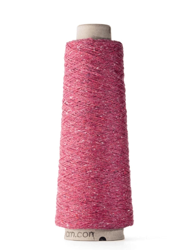 A tall cone of Ito Kinu, a pinkish-red japanilainen silkkilanka with subtle white flecks, wound on a cardboard spool—perfect for kesäneuleisiin projects—stands upright against a white background.