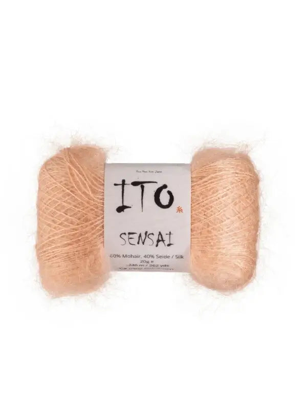 A skein of pale peach Ito Sensai yarn with a white label displaying the brand name, product name, and material composition: 60% mohair and 40% silk. This silkkimohairlanka looks soft and fuzzy—ideal for crafting a luxurious, kevyt neulelanka project.