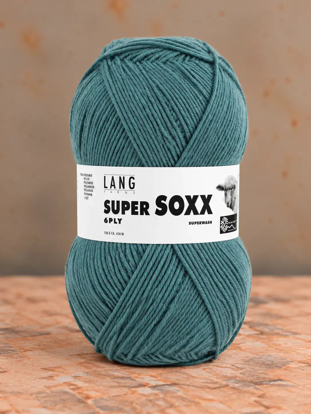 A ball of teal Lang Yarns Super Soxx 6 ply – kestävä sukkalanka villasta yarn with a paper label wrapped around the center.