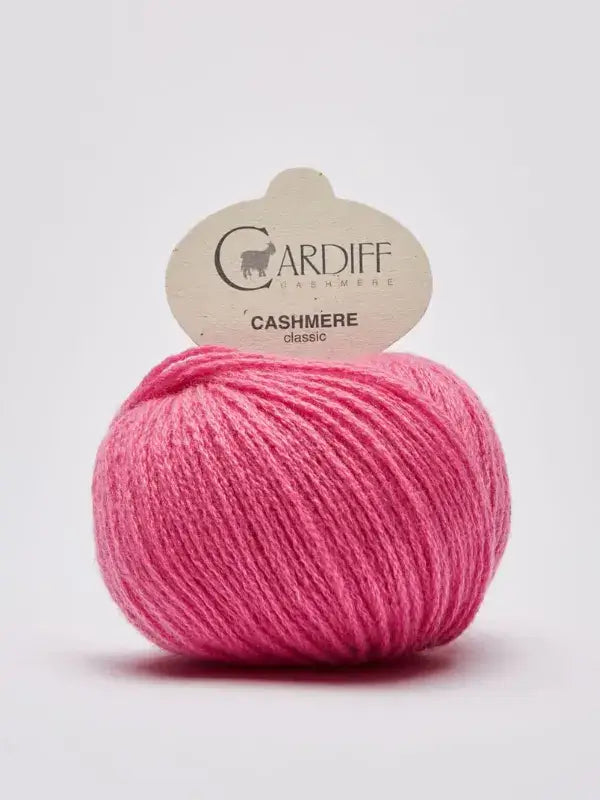 A ball of Cardiff Cashmere Classic – 100% kashmirlanka in pink rests against a plain white background, with its label attached at the top.