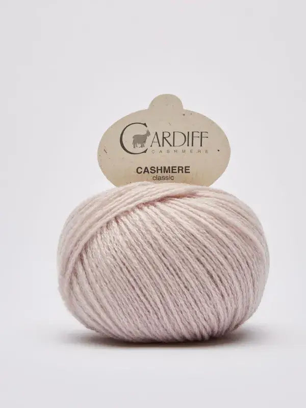 A ball of light pink Cardiff Cashmere Classic – 100 % kashmirlanka yarn with its label is displayed against a plain white background.