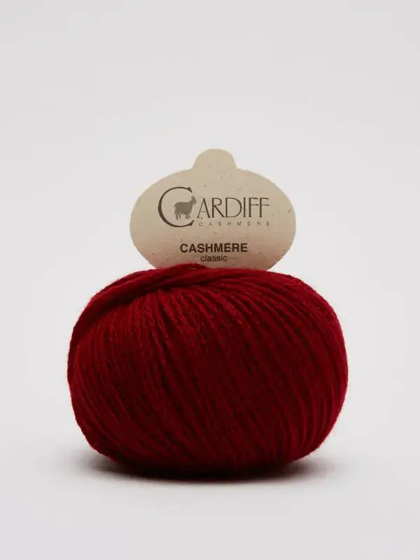 A ball of red yarn labeled “Cardiff Cashmere Classic – 100 % kashmirlanka” is displayed against a plain white background.