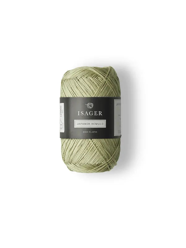 A light green Isager Japansk Bomuld yarn ball with a black and white label featuring the brand and details, shown on a white background. Perfect for kesäneuleet projects.
