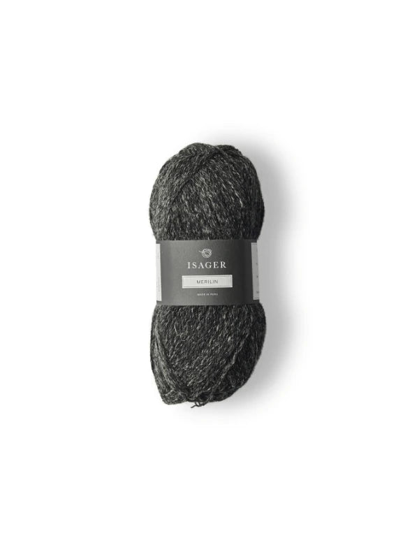 A skein of dark grey, marled Isager Merlin yarn with a black and grey label is centered on a white background.