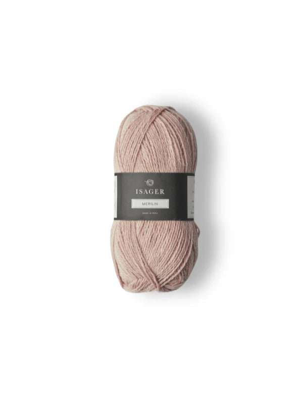 A skein of pale pink Isager Merlin yarn with a black and gray label, photographed on a white background.