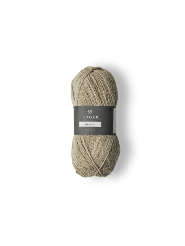 A skein of light brown Isager Merlin yarn with a dark gray label is displayed on a white background.