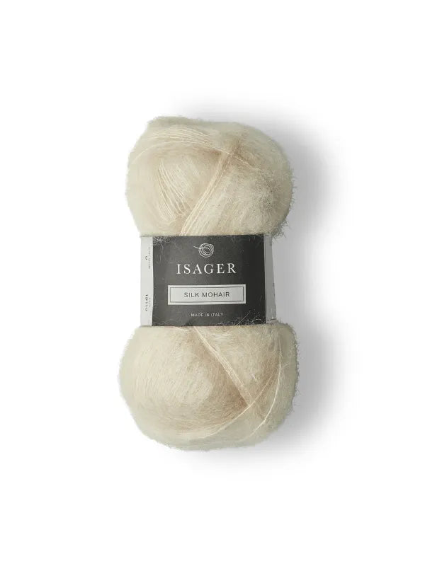 A skein of Isager Silk Mohair yarn in a soft, off-white shade, wrapped with a gray and black label reading “Isager Silk Mohair, Made in Italy,” displayed against a white background—ideal for knitting your next project using the PetiteKnit Stockholm Sweater neuleohje ja Isager Silk Mohair.