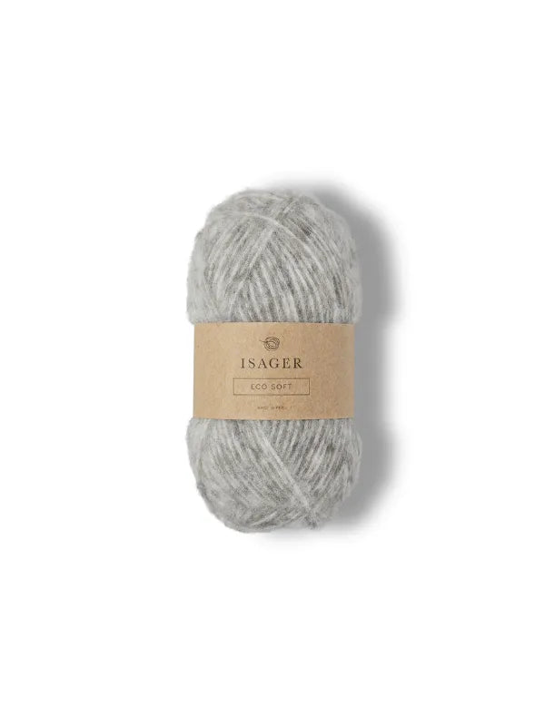 A skein of Isager Soft in light grey with white flecks, wrapped in a brown ISAGER SOFT label, is shown against a white background—ideal for soft knitting projects.
