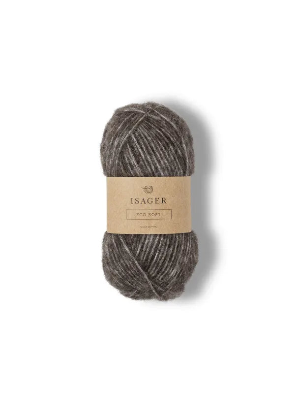 A skein of gray, fuzzy yarn labeled Isager Soft, pehmeä neulelanka, is wrapped with a brown paper band and centered on a white background.