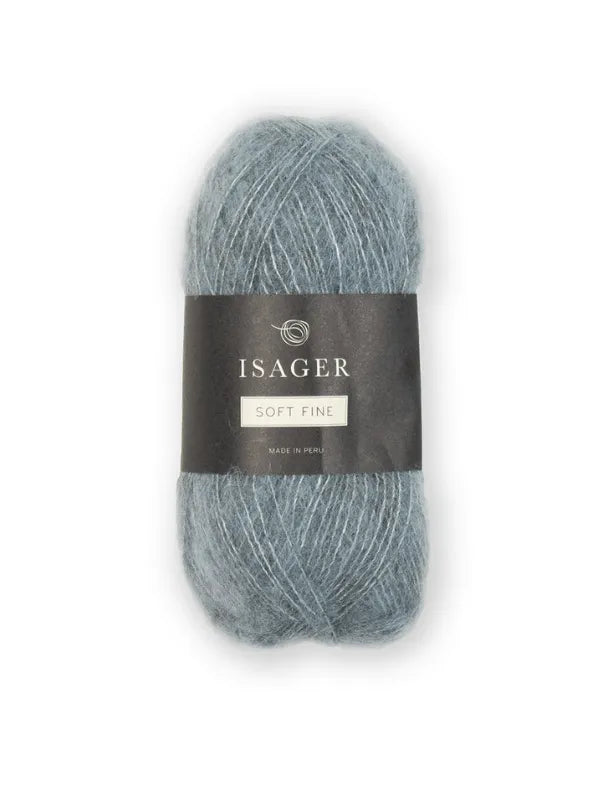 A skein of light blue-gray Isager Soft Fine yarn with a black and white center label, displayed on a plain white background.