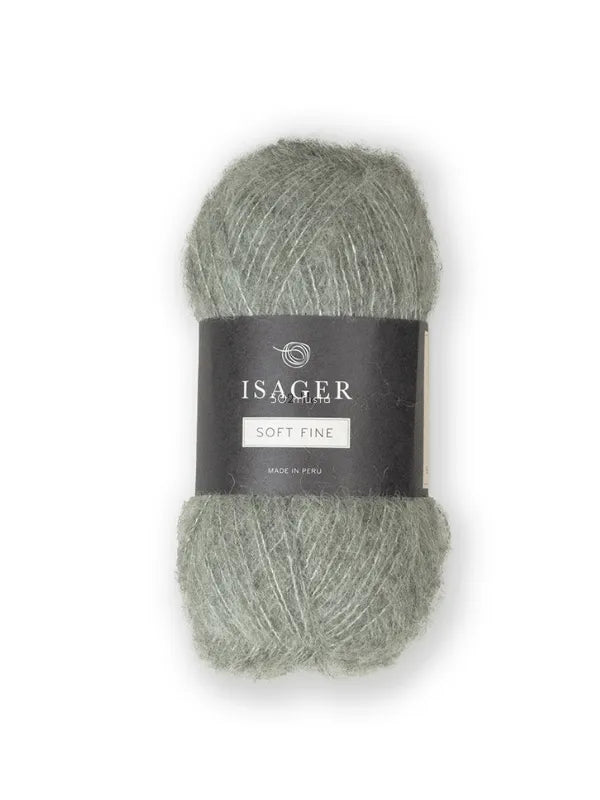 A skein of Isager Soft Fine in muted green, wrapped with a black Isager label, made in Peru. This alpaca-silk yarn has a soft, fuzzy texture—perfect for lace-weight projects.