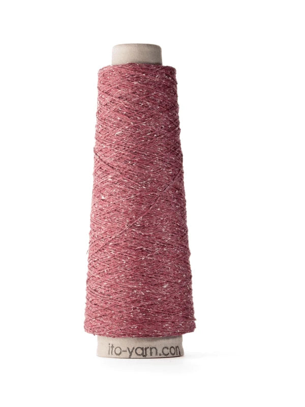 A cone of pink, textured Ito Kinu japanilainen silkkilanka with visible specks is wound around a white spool labeled ito-yarn.com, standing upright on a white background. Perfect for kesäneuleisiin.