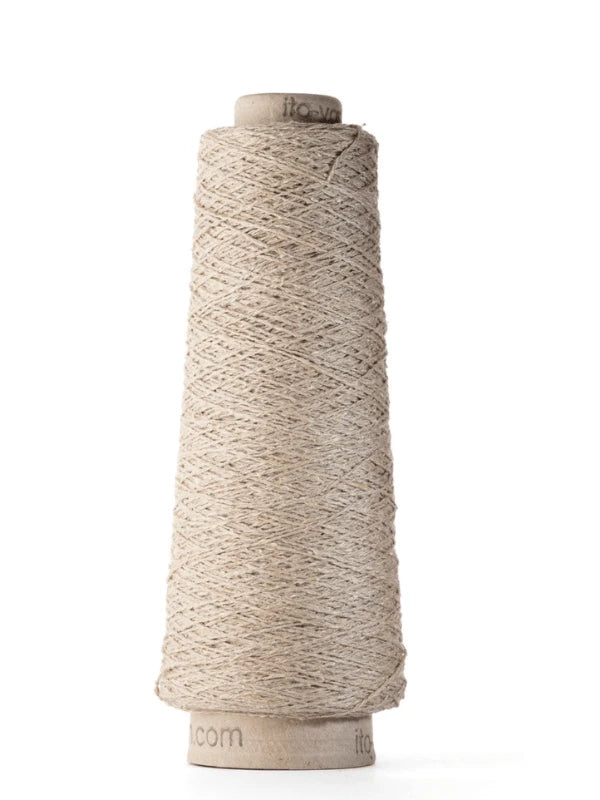 A cone-shaped spool of Ito Kinu natural beige silk yarn is wound on a cylindrical cardboard core, standing upright against a white background—crafted from 100% silk and ideal for kesäneuleisiin.