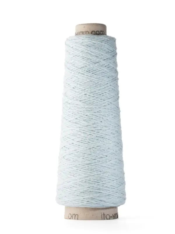 A tall spool of Ito Yarn Shimo in light blue, wound around a cardboard cone, stands upright against a plain white background.